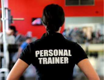 A woman standing defines that she is a personal trainer, at tranceform fitness which is a leading gym and fitness club in Pune has certified trainers